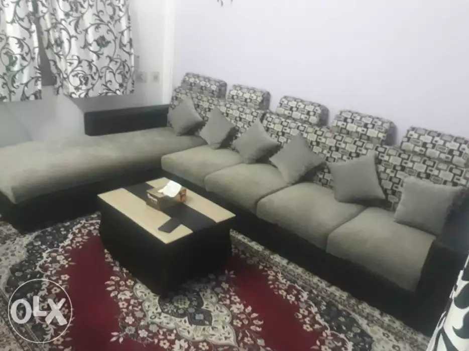 L-shaped sectional sofa in grey upholstery with patterned back cushions